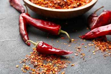 Dry chili peppers and flakes on table