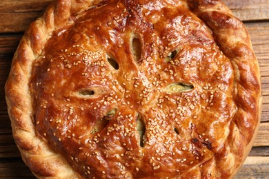 Photo of Tasty homemade pie with filling on wooden table, top view