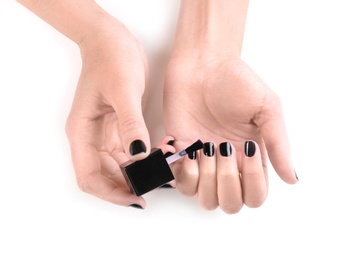 Woman applying nail polish on white background, top view