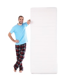 Photo of Young man with comfortable mattress isolated on white