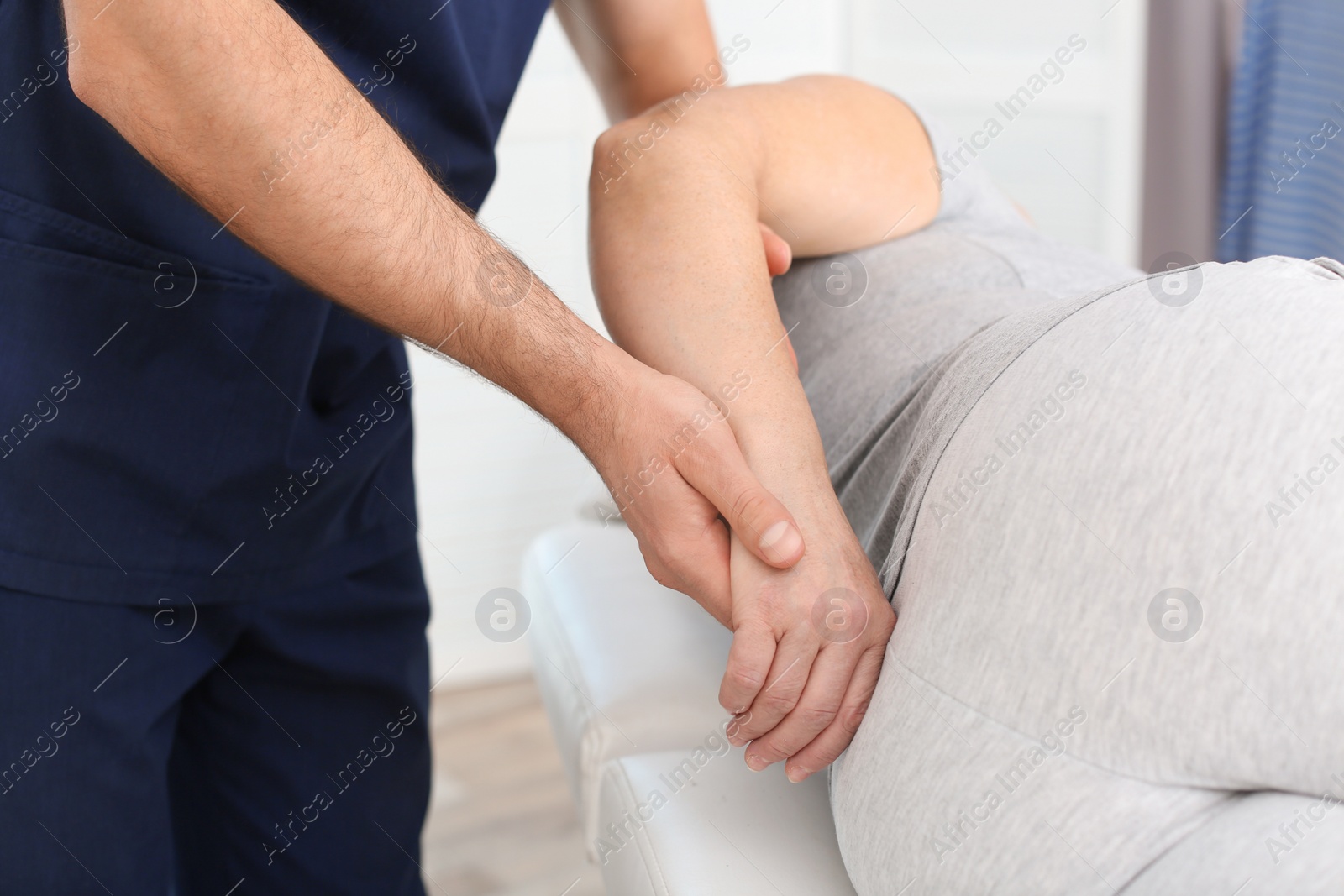 Photo of Physiotherapist working with patient in clinic, closeup. Rehabilitation therapy