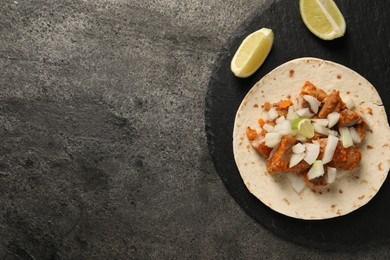 Photo of Delicious taco with vegetables, meat and lime on grey textured table, top view. Space for text