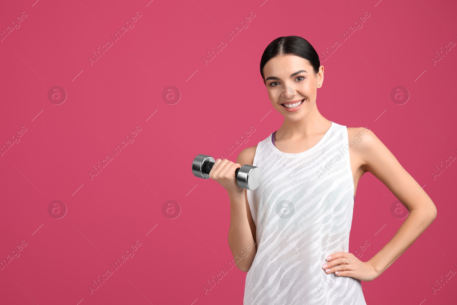 Photo of Woman with dumbbell as symbol of girl power on pink background, space for text. 8 March concept