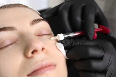 Photo of Cosmetologist giving facial injection to patient indoors, closeup. Cosmetic surgery