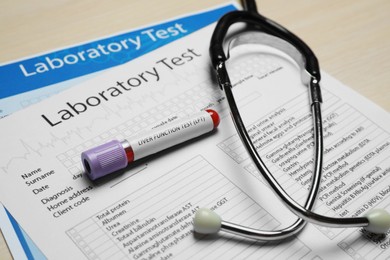 Photo of Liver Function Test. Tube with blood sample, stethoscope and laboratory forms on table