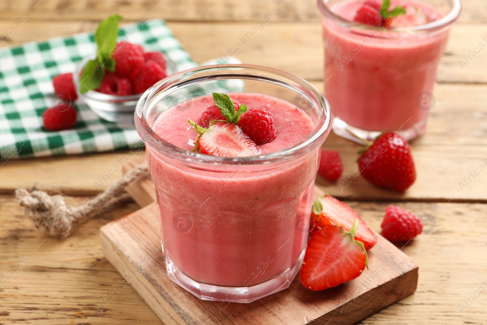 Photo of Delicious berry mousse with mint on wooden table