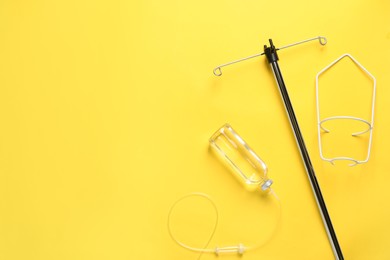 IV infusion set on yellow background, flat lay. Space for text