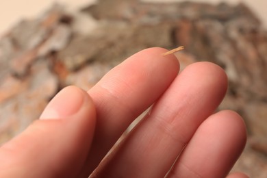 Photo of Woman with splinter in her finger on blurred background, closeup