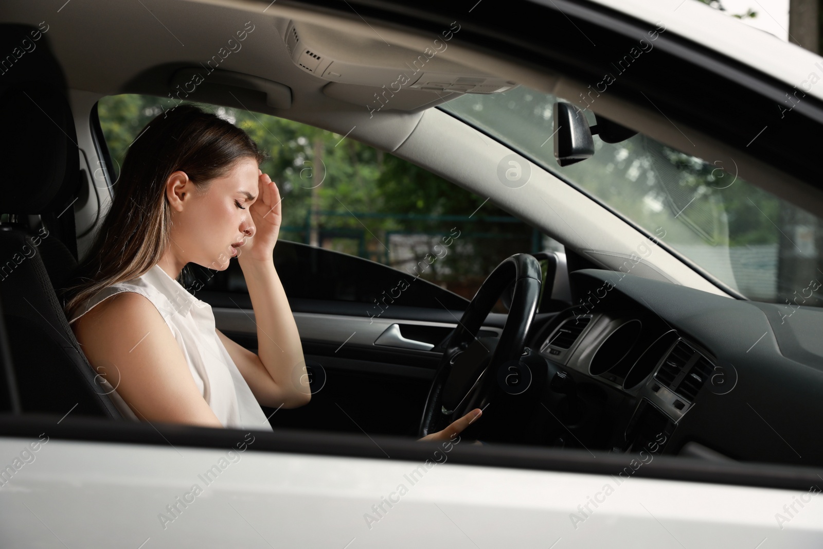 Photo of Stressed young woman in driver's seat of modern car