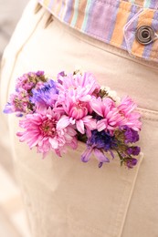 Photo of Woman wearing jeans with flowers in pocket, closeup