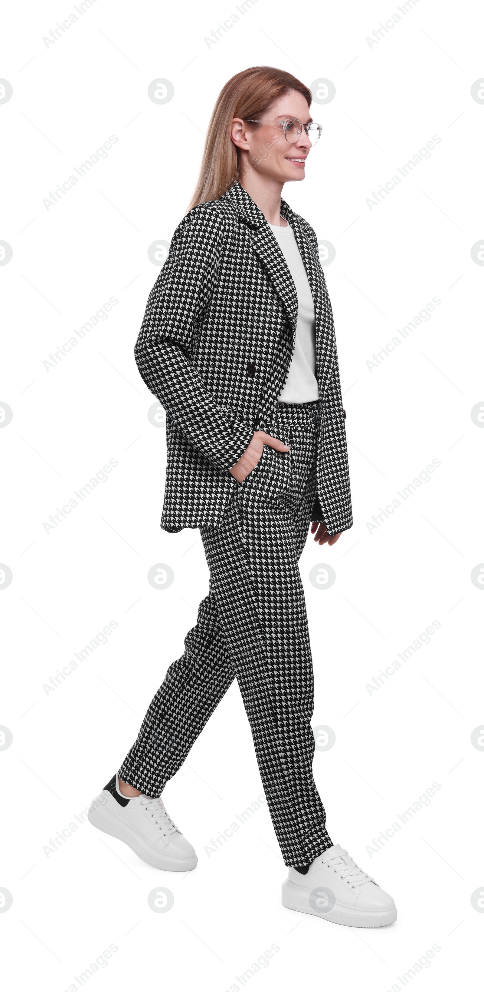 Photo of Beautiful happy businesswoman in suit walking on white background