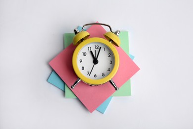 Alarm clock and reminder notes on light grey background, top view