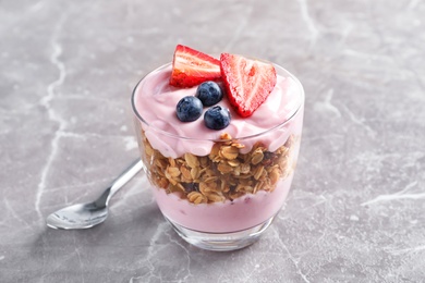 Glass with yogurt, berries and granola on table