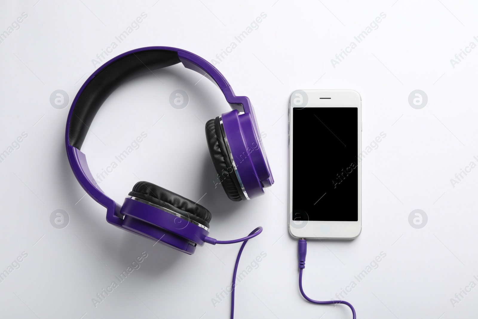 Photo of Stylish headphones and modern phone on white background, top view. Space for text