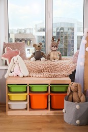 Stylish child room with storage for toys near window