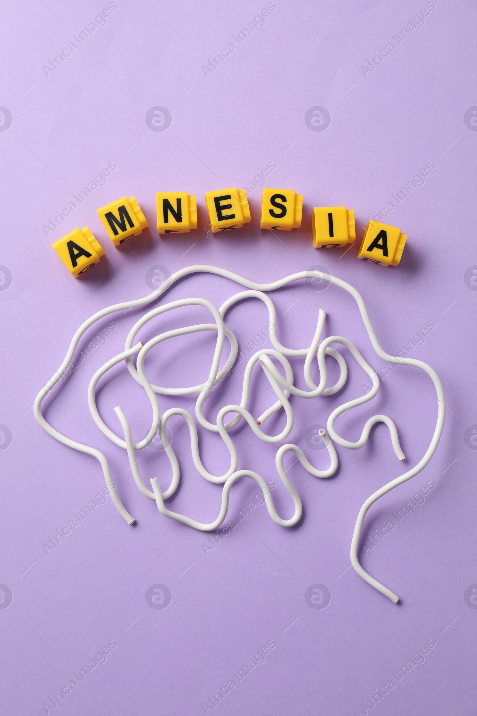 Photo of Word Amnesia and brain made of wires on violet background, flat lay