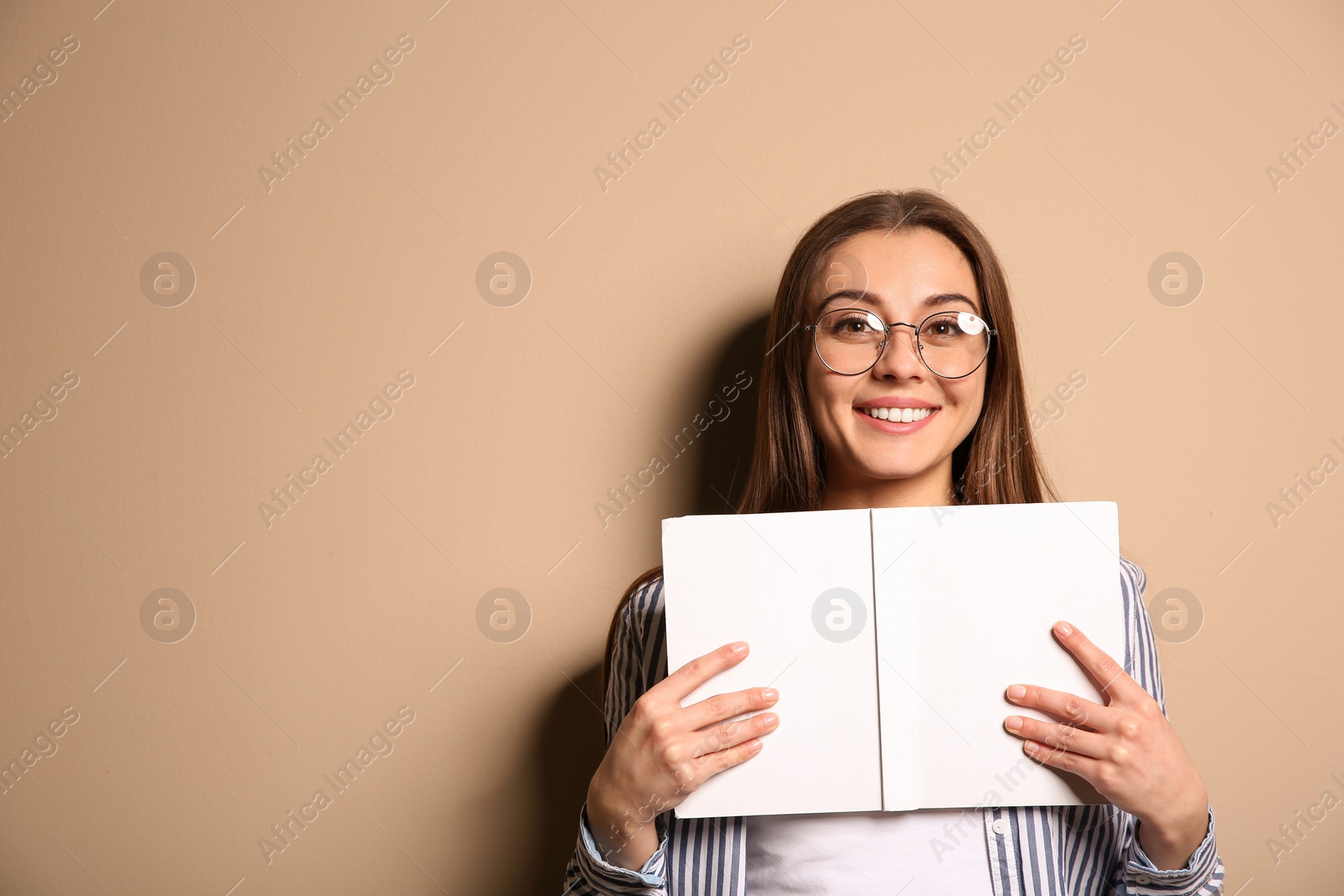 Photo of Young woman with book on color background, space for text