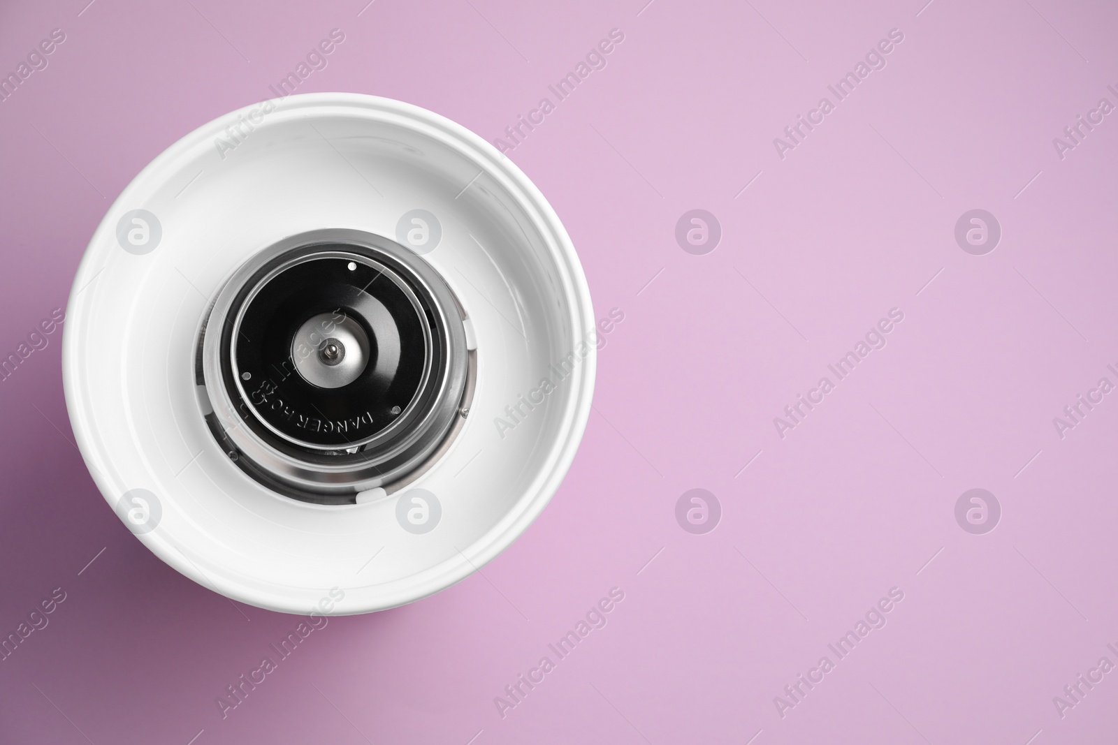 Photo of Portable candy cotton machine on violet background, top view. Space for text