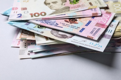 Photo of Ukrainian money on light grey background, closeup. National currency