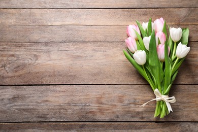 Photo of Beautiful pink spring tulips on wooden background, top view. Space for text