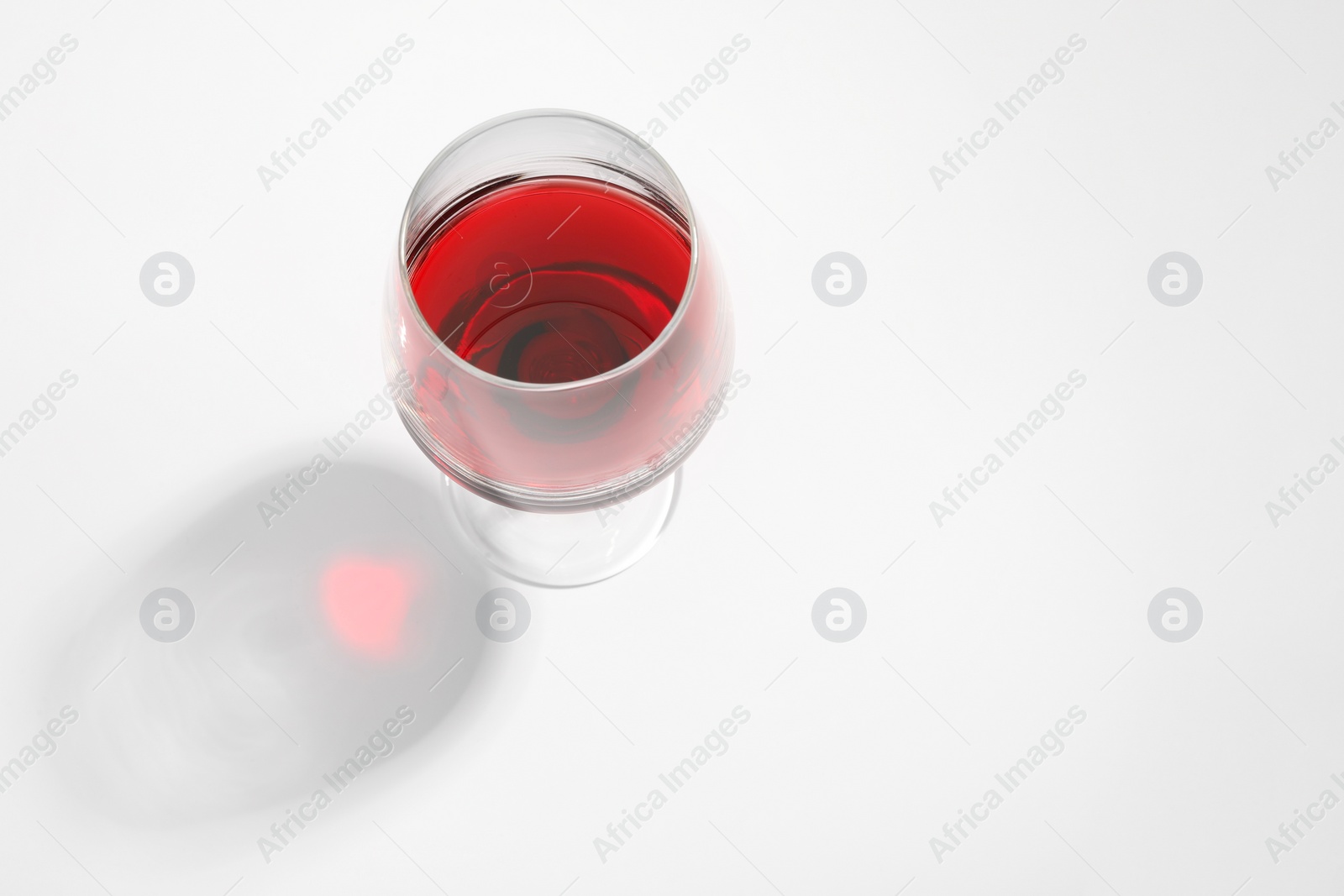 Photo of Tasty red wine in glass isolated on white, above view