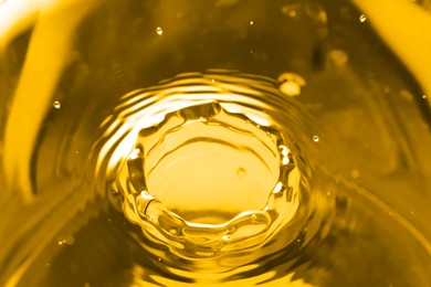 Image of Splash of golden oily liquid as background, closeup