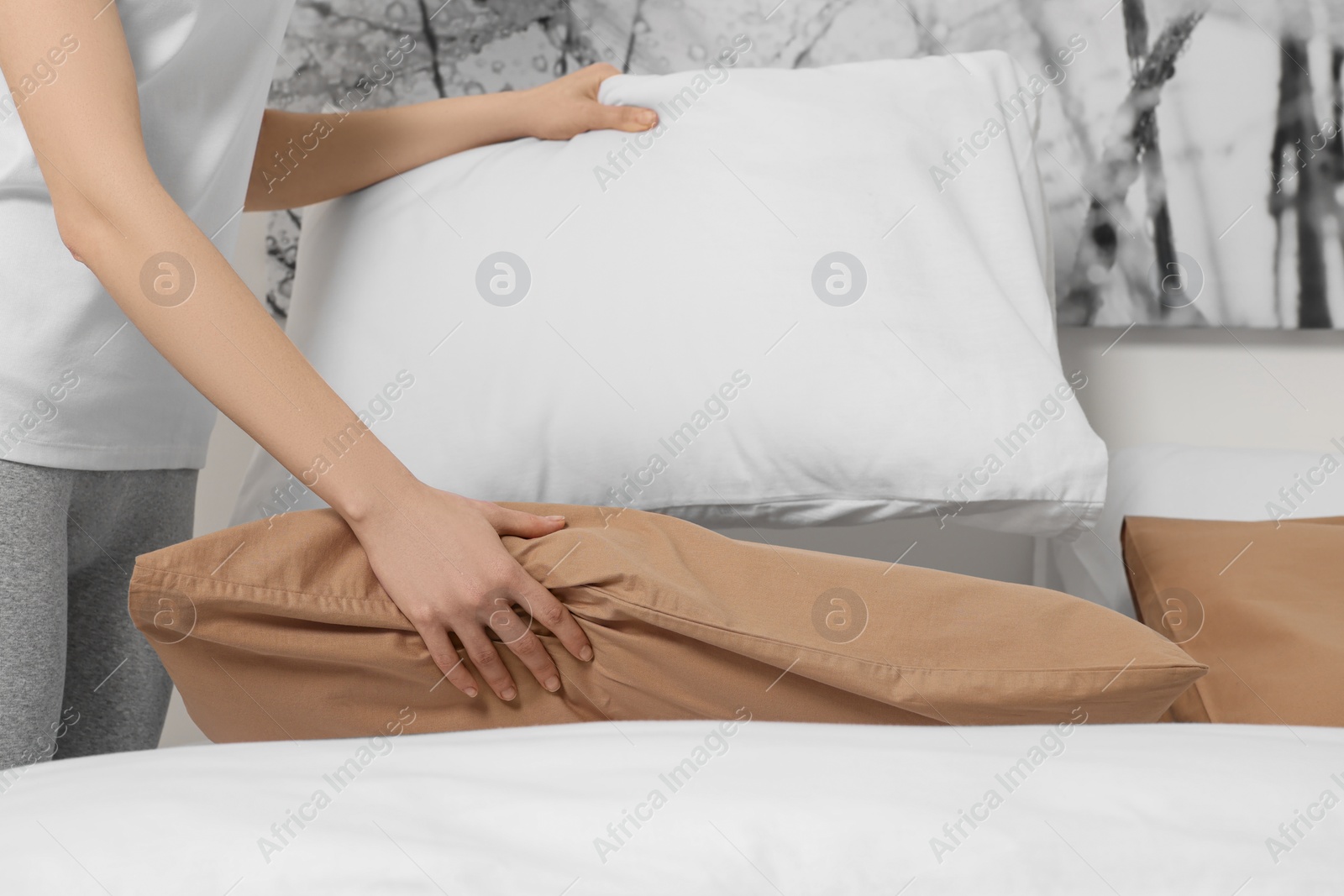 Photo of Young woman making bed in room, closeup