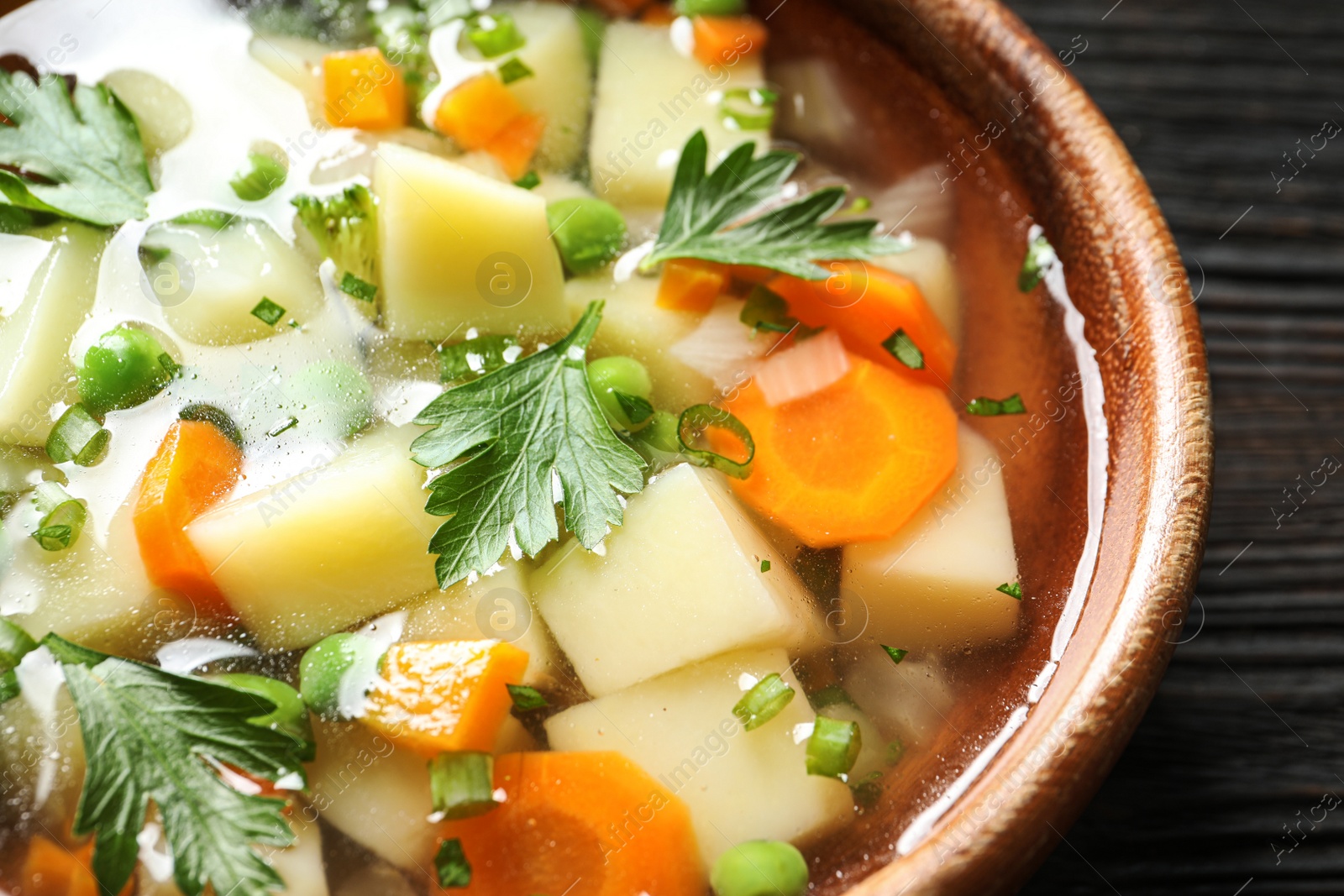 Photo of Bowl of fresh homemade vegetable soup on table, closeup