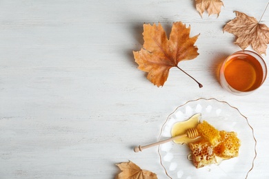 Photo of Flat lay composition with honey and comb on wooden background. Space for text