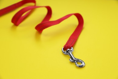 Photo of Red dog leash on yellow background, closeup
