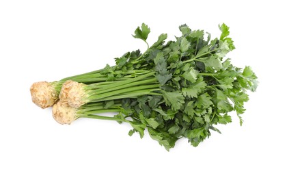 Photo of Fresh raw celery roots with stalks isolated on white, top view