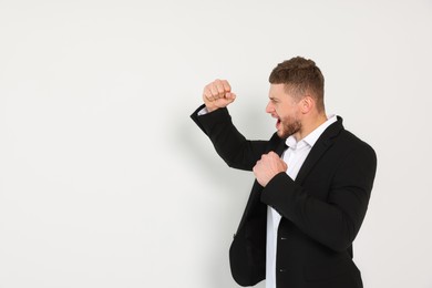 Photo of Young man ready to fight on white background, space for text