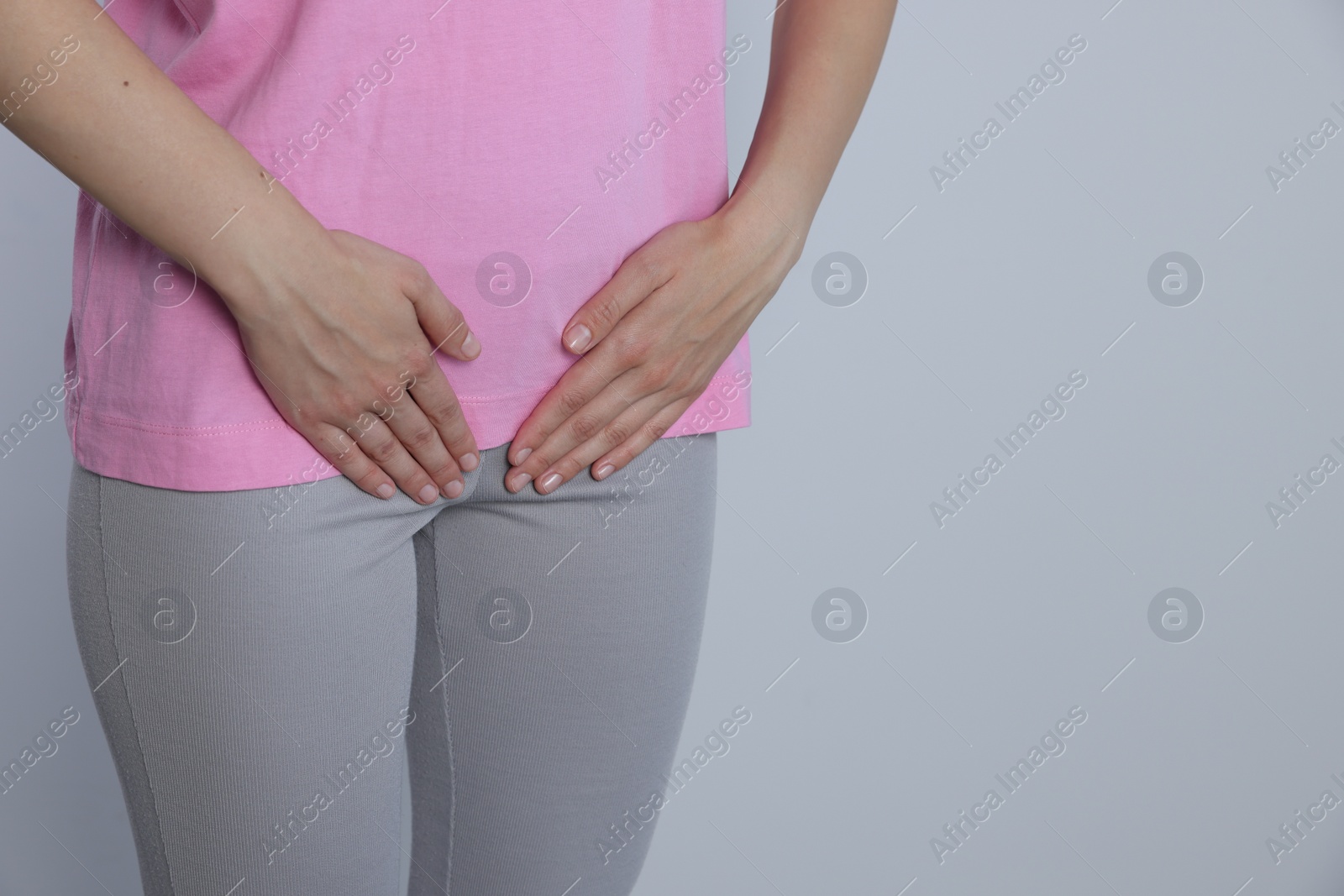 Photo of Woman suffering from herpes genital on grey background, closeup. Space for text