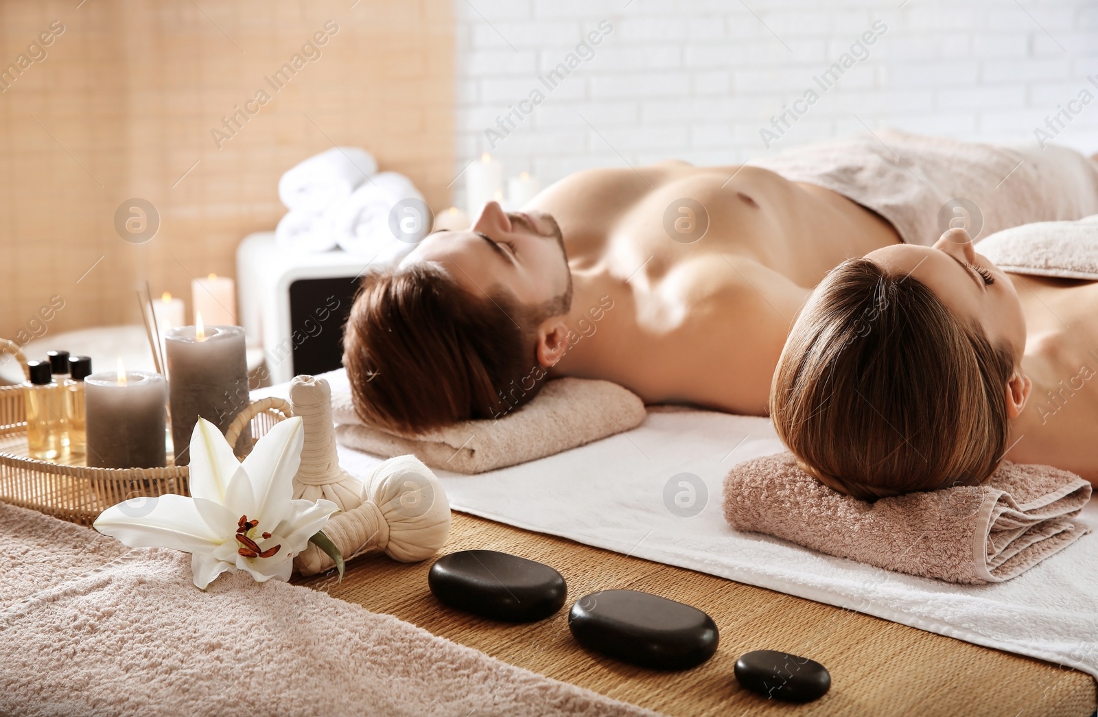 Photo of Young couple with spa essentials in wellness center