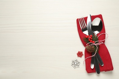 Photo of Cutlery set and festive decor on white wooden table, flat lay with space for text. Christmas celebration