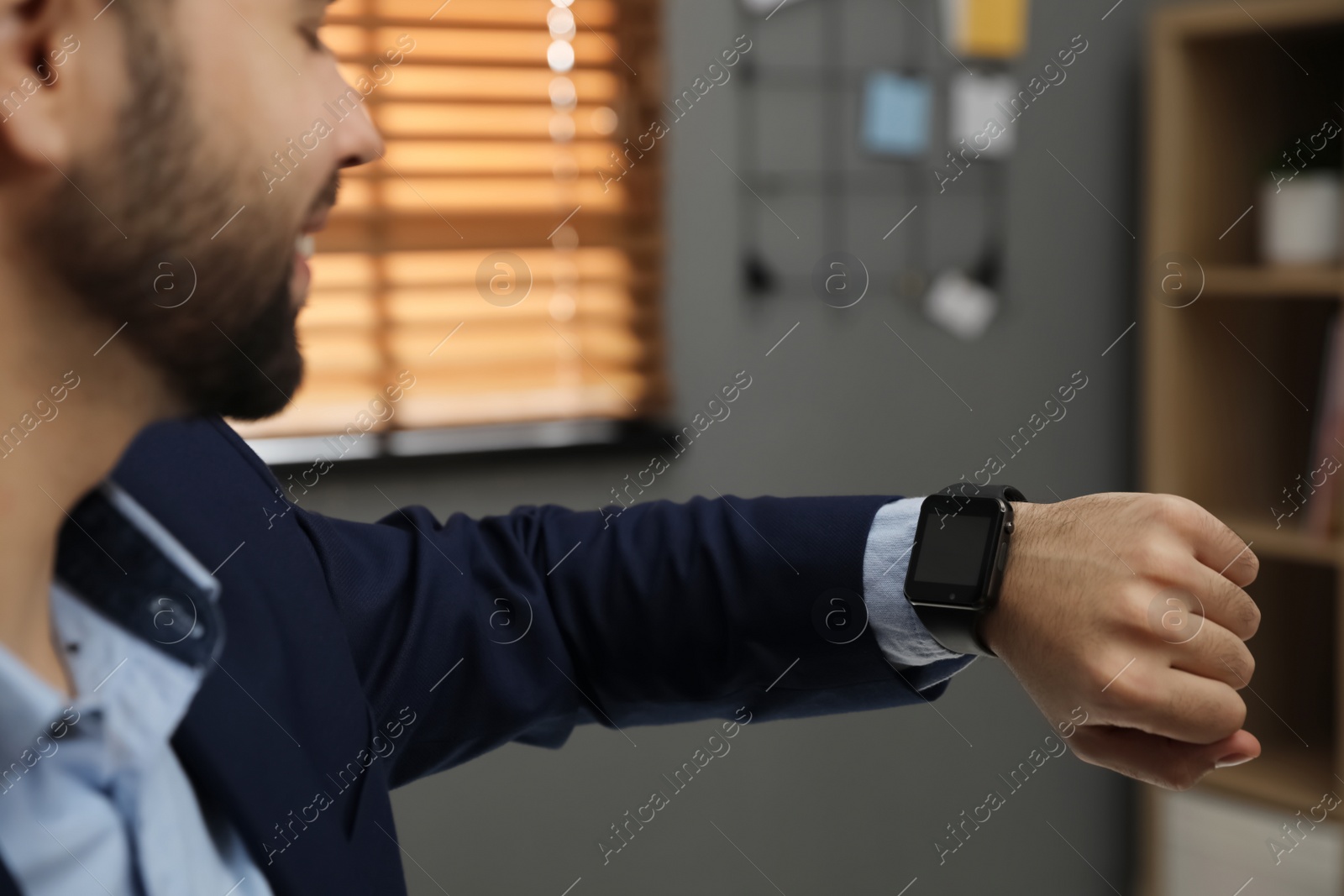 Photo of Businessman looking at smart watch in office