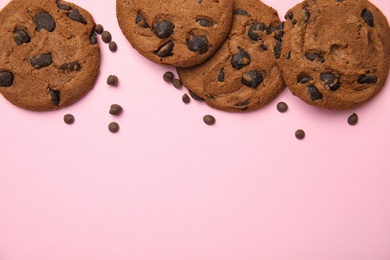 Photo of Delicious chocolate chip cookies on color background, flat lay. Space for text