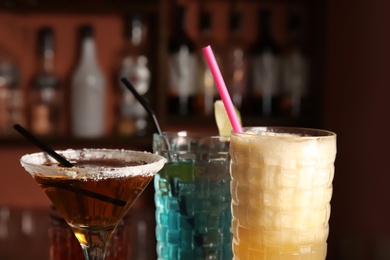 Photo of Glasses with different delicious cocktails, closeup