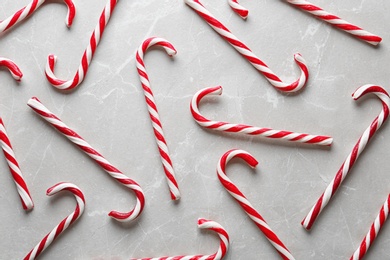 Photo of Flat lay composition with candy canes on grey marble background. Traditional Christmas treat