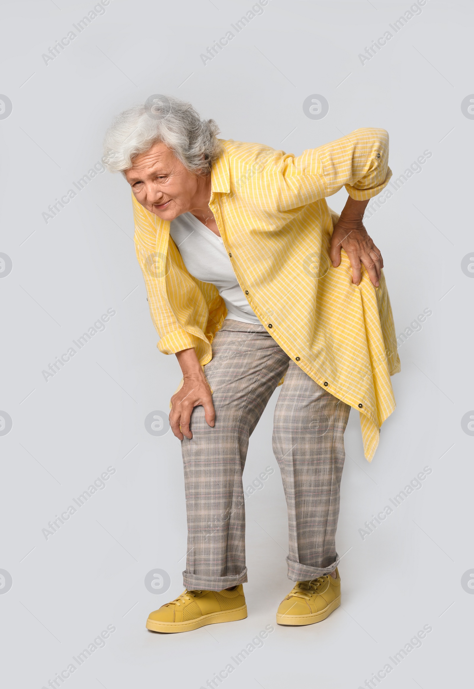 Photo of Full length portrait of senior woman having knee problems on grey background