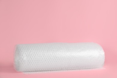 Bubble wrap roll on pink background, space for text