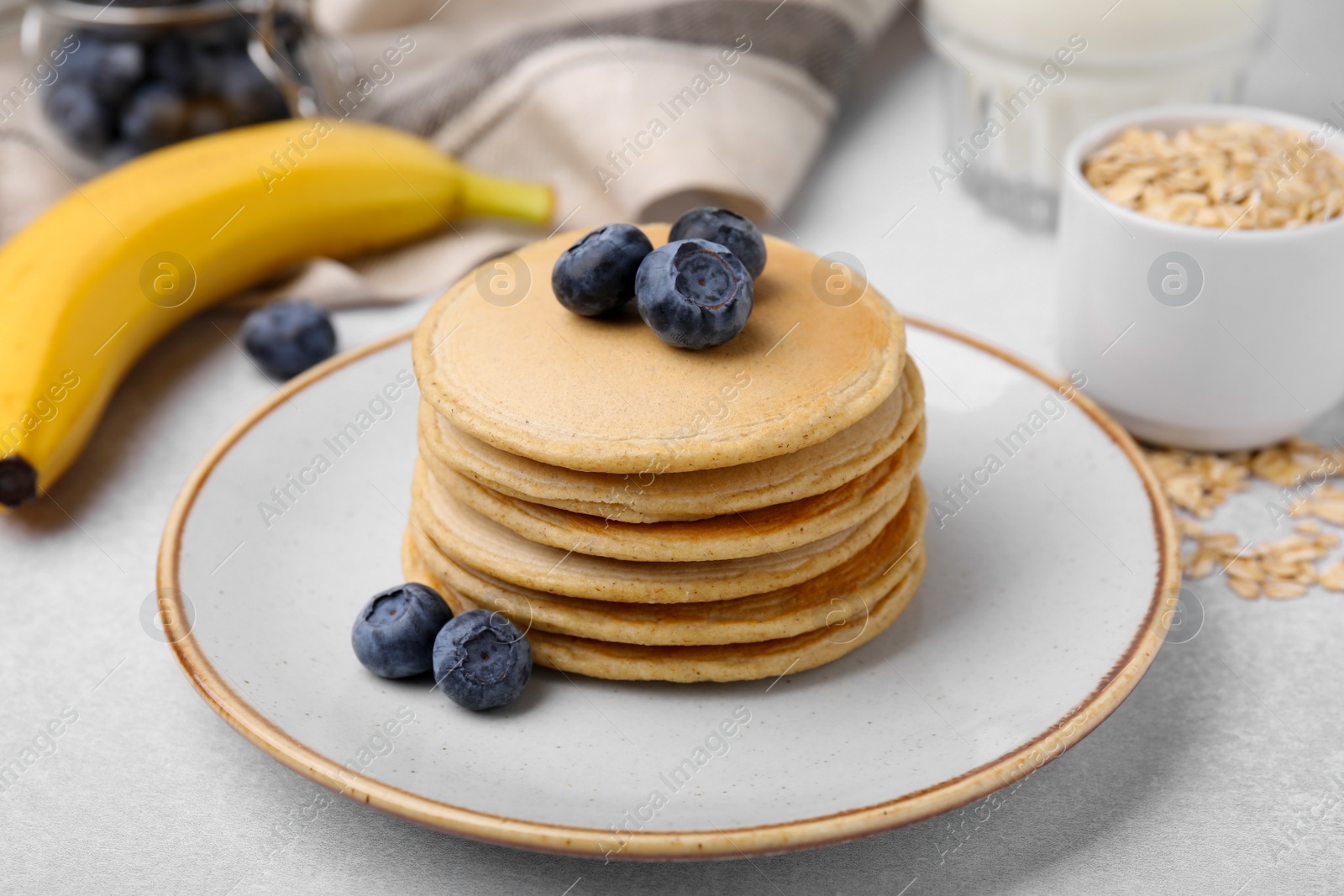 Photo of Tasty oatmeal pancakes on grey table, closeup