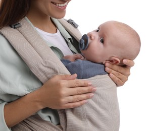 Mother holding her child in baby carrier on white background, closeup