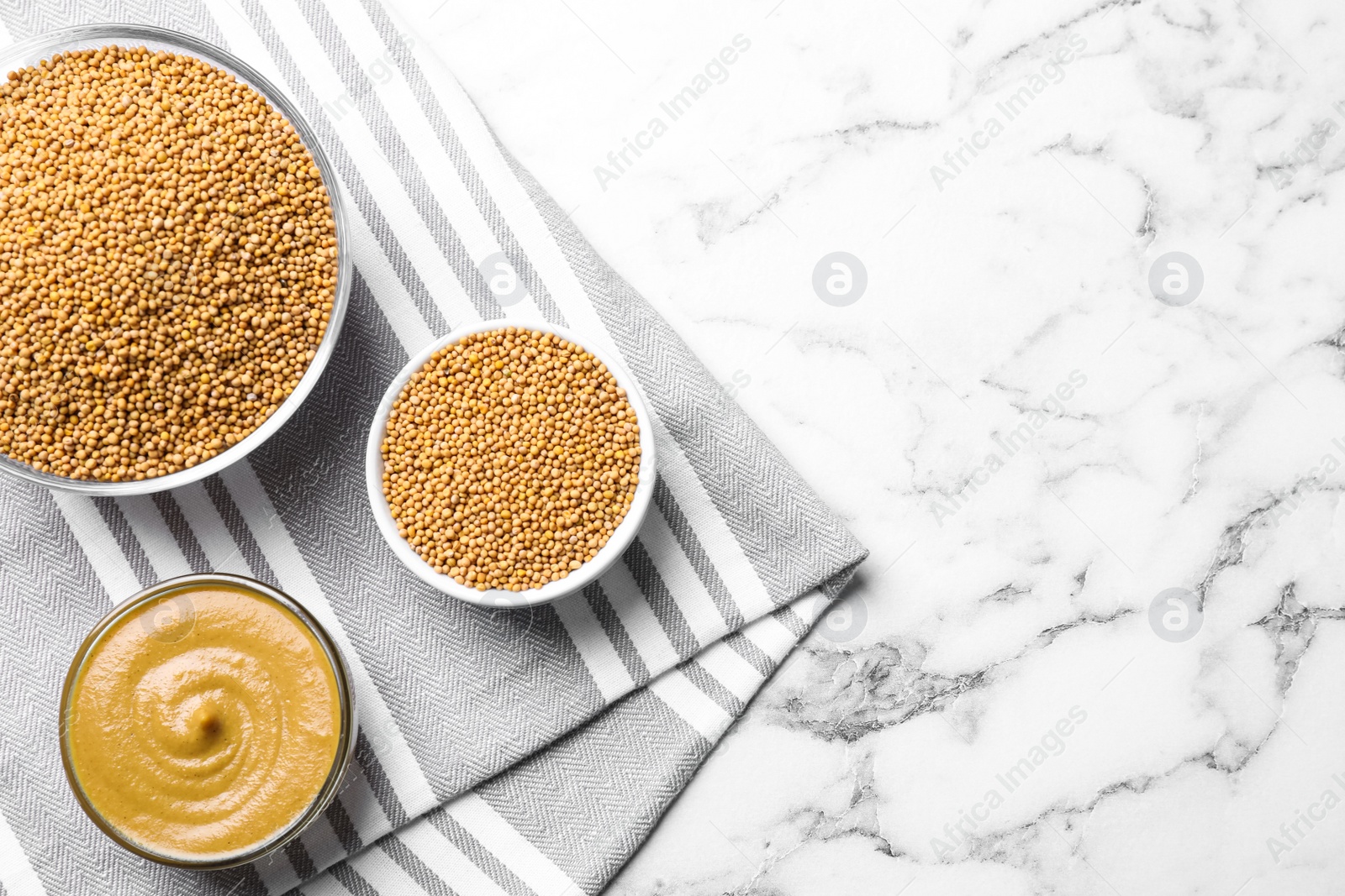 Photo of Flat lay composition with mustard seeds on white marble table, space for text