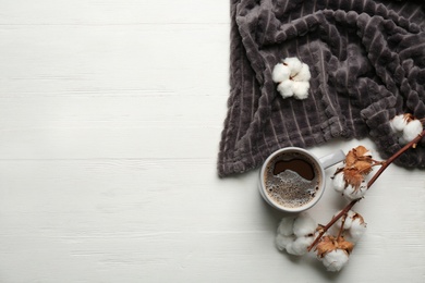 Photo of Flat lay composition with hot drink and warm plaid on white wooden table, space for text
