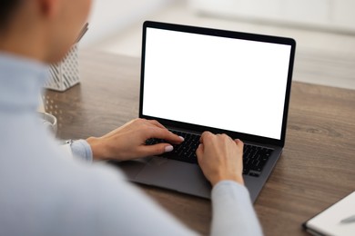 Photo of Young woman watching webinar at table indoors, closeup