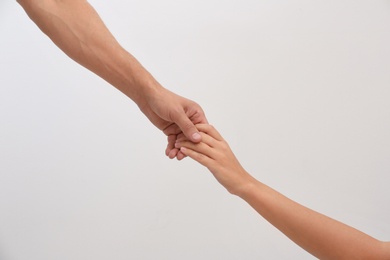 People holding hands together on light background. Concept of support and help