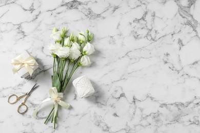 Photo of Flat lay composition with scissors and flowers on white marble background, space for text