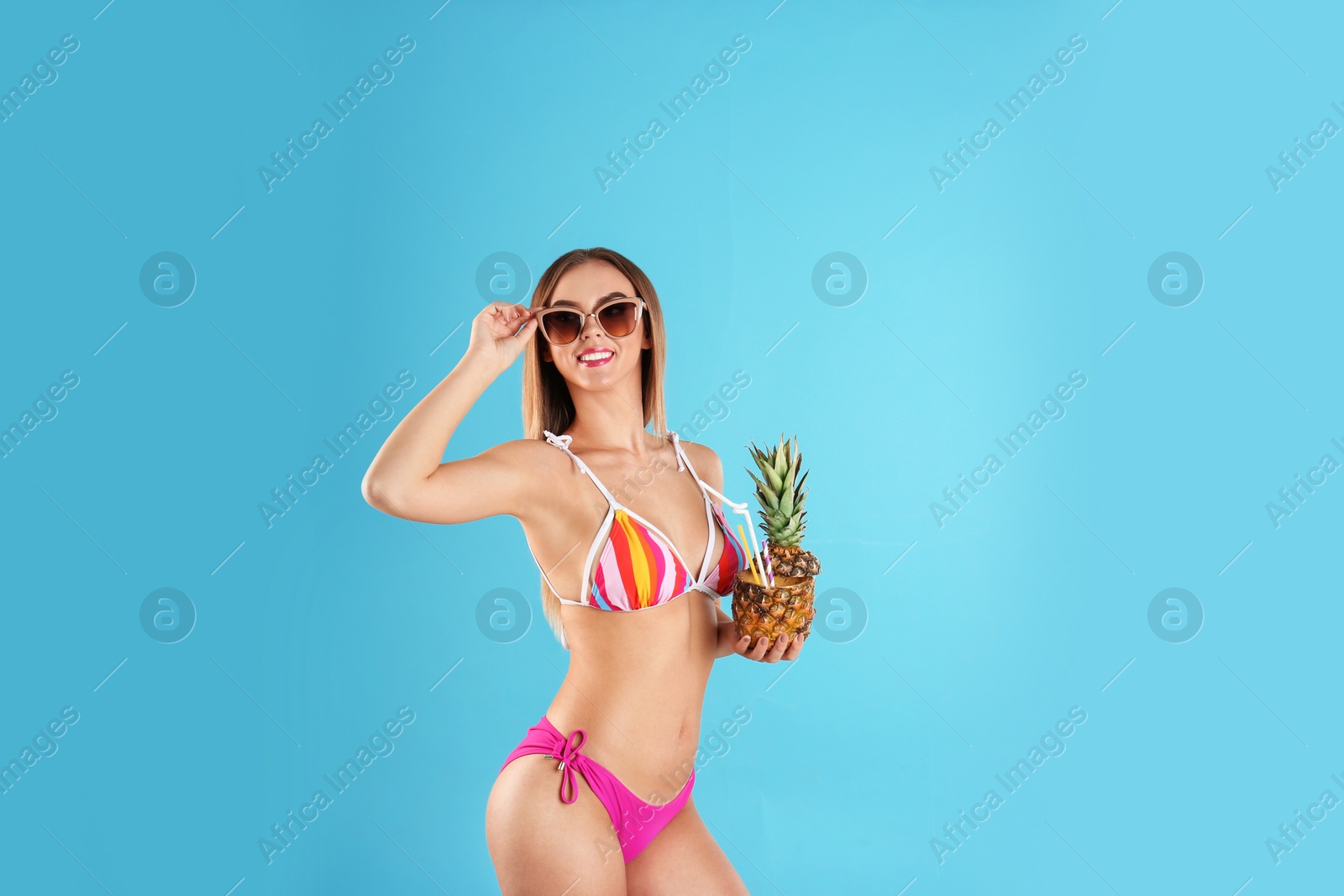 Photo of Pretty sexy woman in stylish bikini with cocktail on color background, space for text