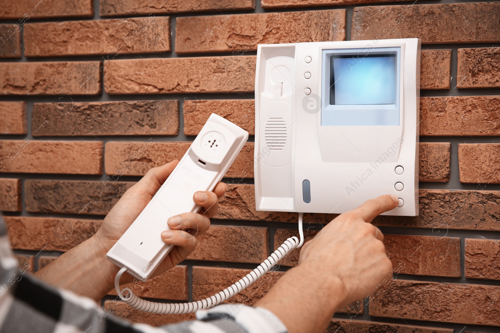 Photo of Man pressing button on intercom panel indoors, closeup